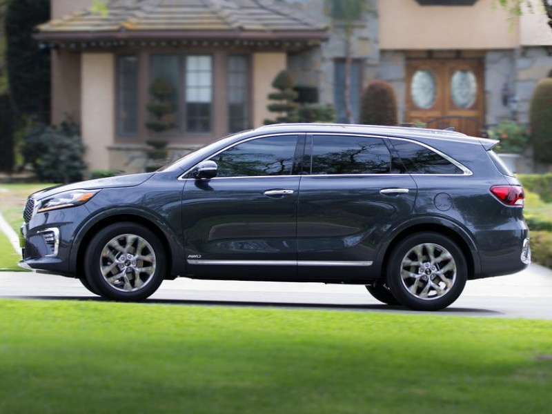 Driver Side Exterior of a gray blue 2019 Kia Sorento driving around down a neighborhood street