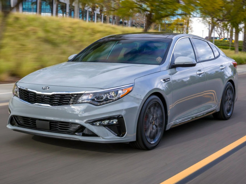 Front exterior view of a 2019 Kia Optima speeding down an open highway