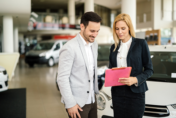 when to trade in your vehicle at Superior Toyota in Erie | Sale associate showing man financial information Sale associate showing man financial information