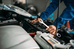 Car mechanic working on car under the hood