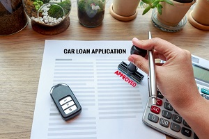 Employee stamping an approval stamp on a car loan application
