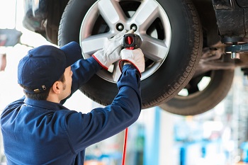 Service technician working on a tire on a vehicle