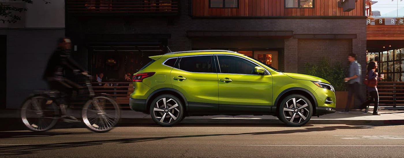 Side view of a  lime green 2021 Nissan Qashqai parked on the side of a city street