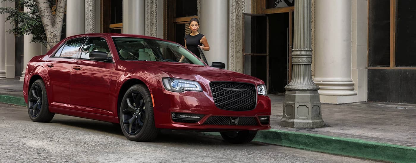 A woman is shown getting into a red 2022 Chrysler 300 after leaving a CDJR dealer near you.