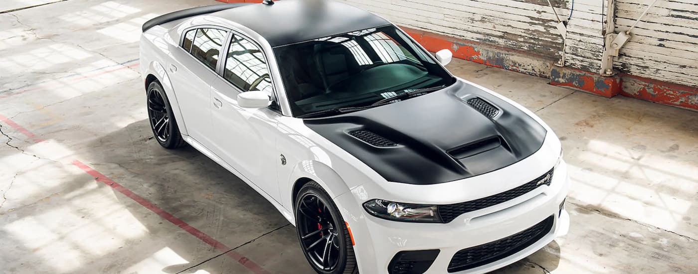 A white 2022 Dodge Charger SRT Hellcat Redeye Widebody is shown parked in a garage.