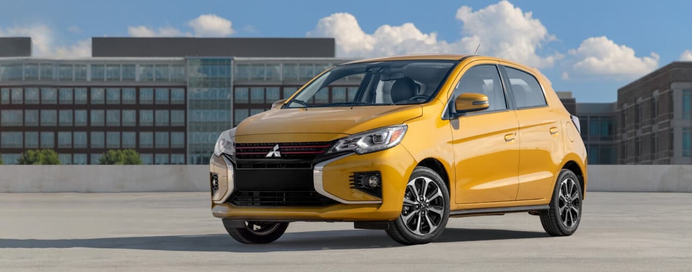 A yellow 2022 Mitsubishi Mirage is shown on top of a parking garage after leaving a Mitsubishi Dealer near you.