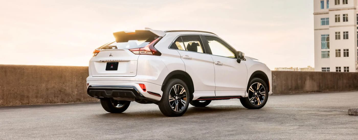 A white 2022 Mitsubishi Eclipse Cross is shown from the side on a sunny day.