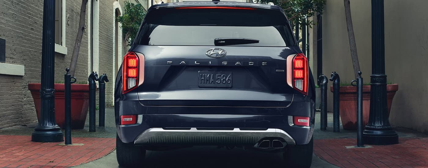 Rear view of a dark colored 2022 Hyundai Palisade Calligraphy parked in an alleyway