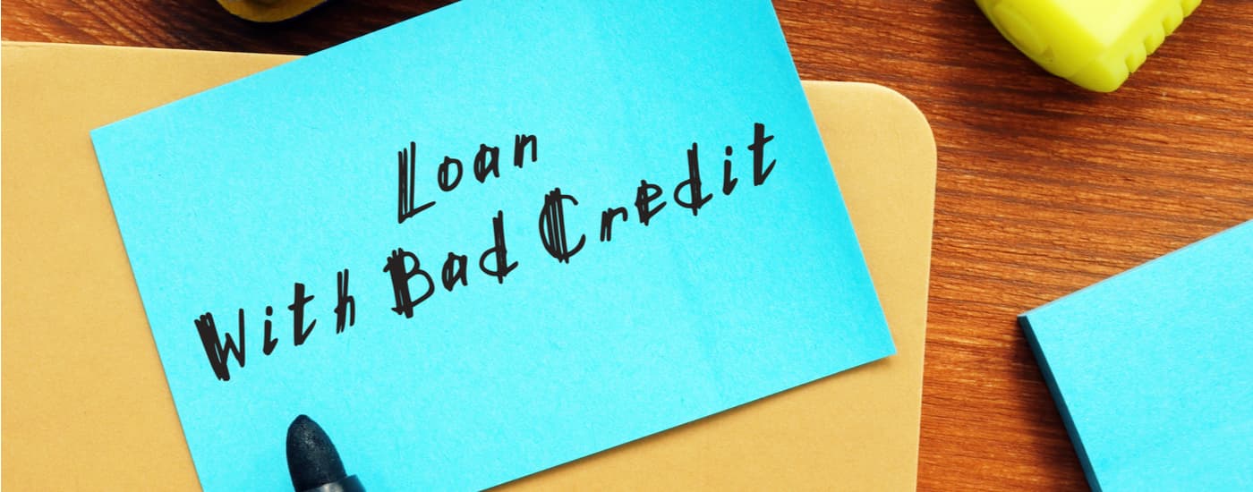 Blue piece of paper sitting on a desk with a note about bad credit auto loans