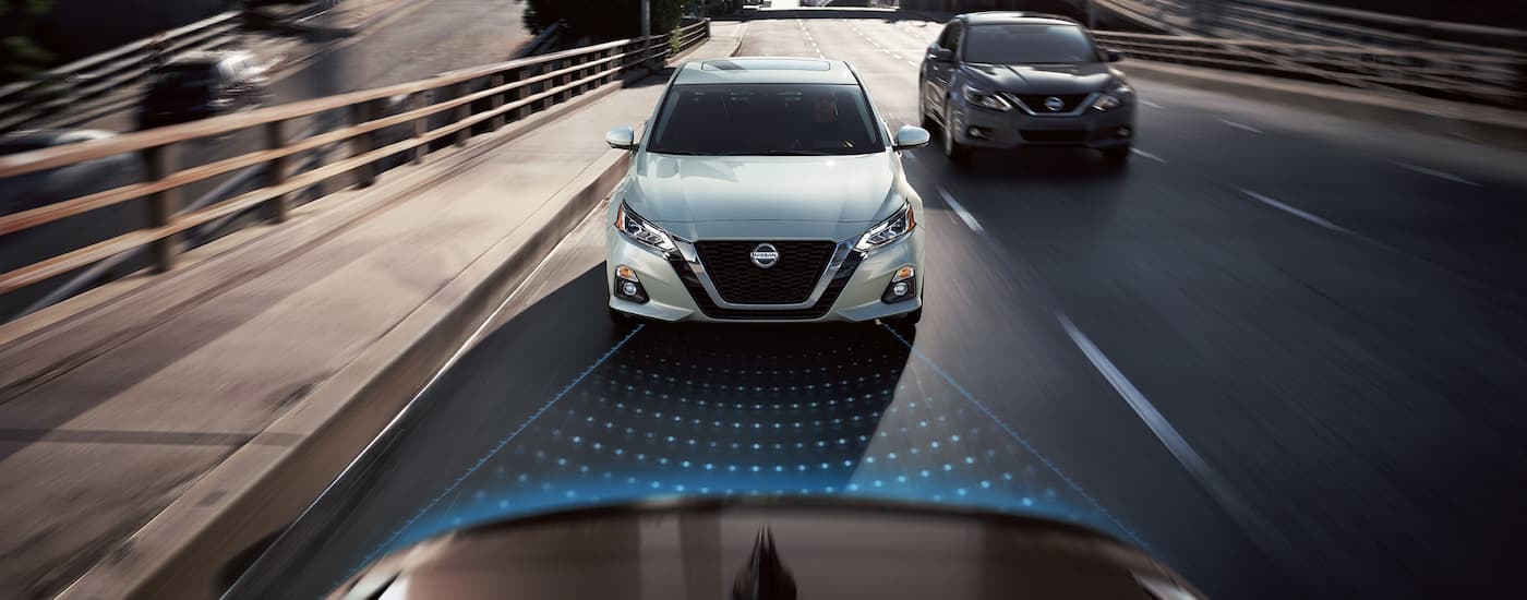 Forward collision sensor graphic coming from a  white 2019 Nissan Altima as it drives on the highway