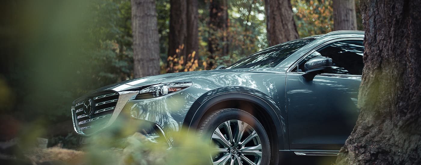 Aqua 2022 Mazda CX-9 parked in the woods after visiting a Mazda Dealer in Leduc