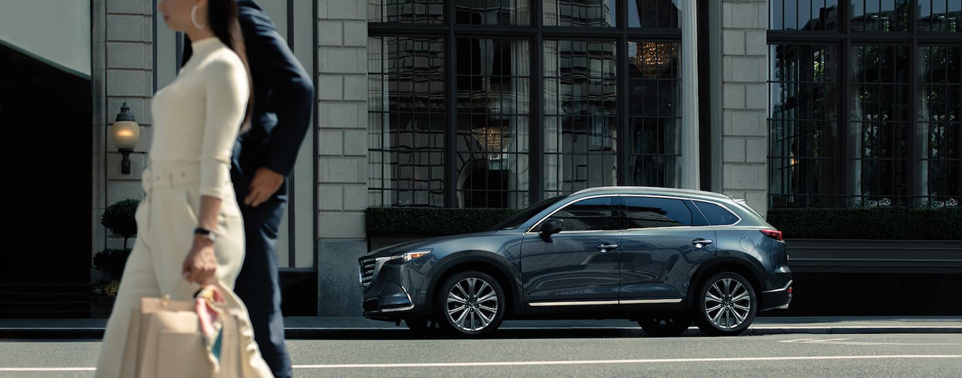Blue 2022 Mazda CX-9 parallel parked on a city street