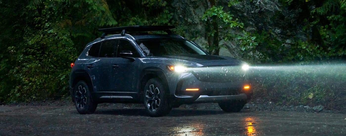 Blue 2023 Mazda CX-50 parked in the rain after leaving a Mazda dealer near you