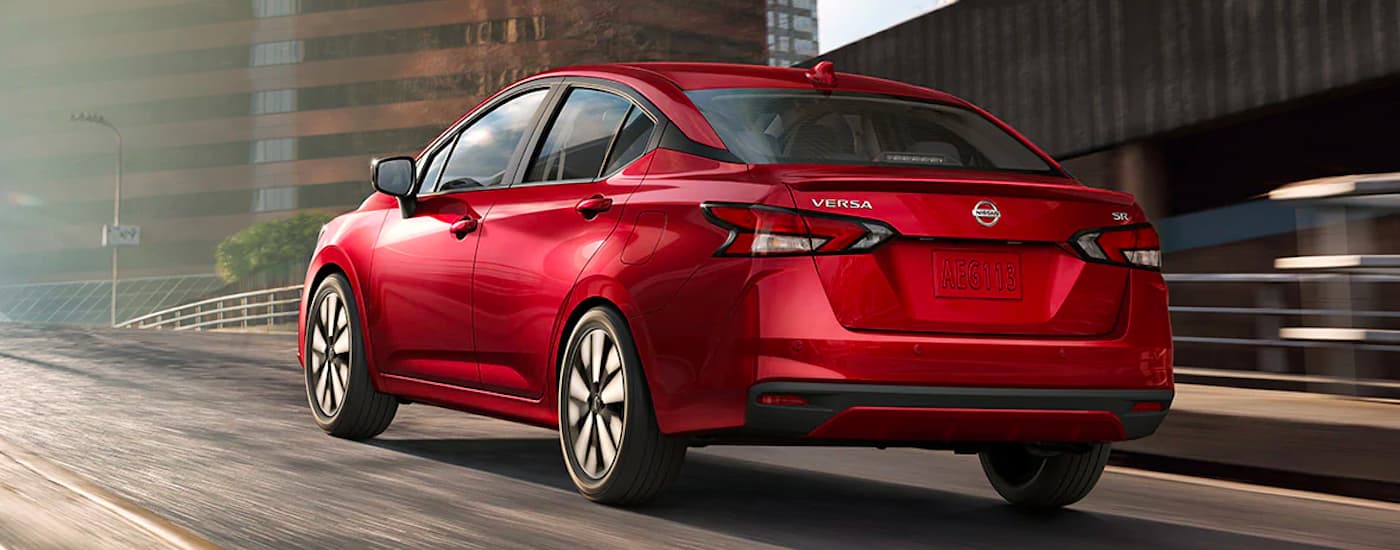 Rear view of a red 2021 Nissan Versa driving up a ramp