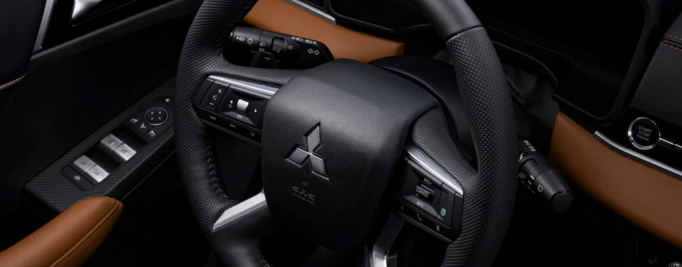 A close up of the steering wheel in a 2022 Mitsubishi Outlander is shown Mitsubishi Dealer in Edmonton. at a 