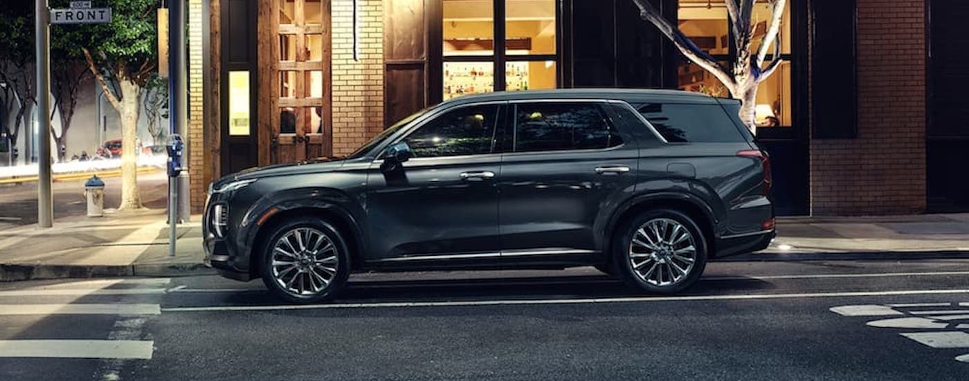 Side view of a black 2020 Hyundai Palisade parked on a city street after leaving a used Hyundai dealership