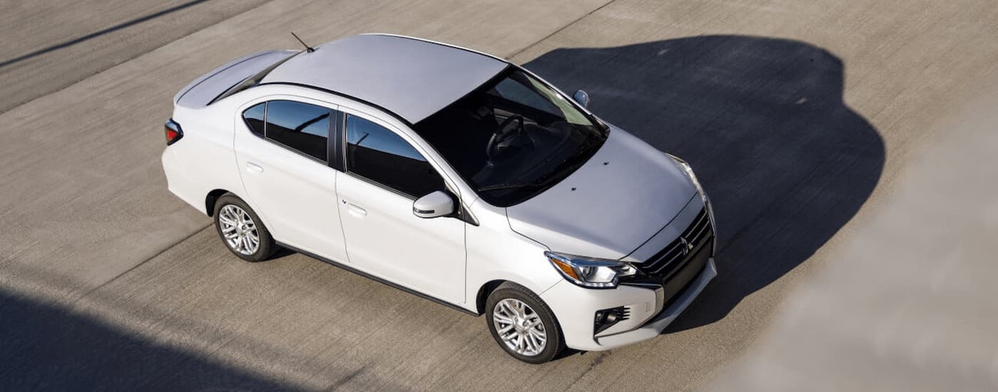 A white 2022 Mitsubishi Mirage is shown at a Mitsubishi dealership in Alberta.