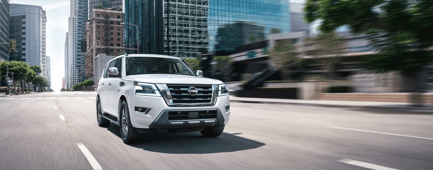 Front view of a white 2022 Nissan Pathfinder driving down the city street after leaving a Nissan dealer