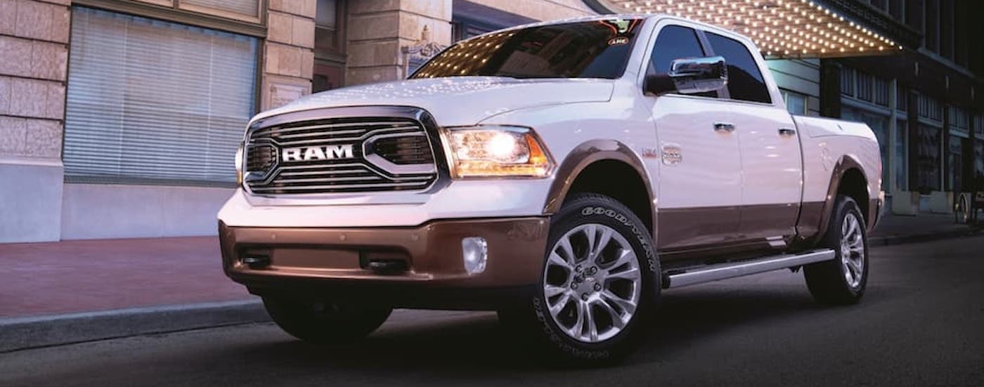 A white 2018 Ram 1500 is shown parked on the side of a city street.