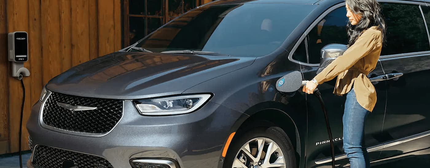 A grey 2022 Chrysler Pacifica Hybrid is shown charging.