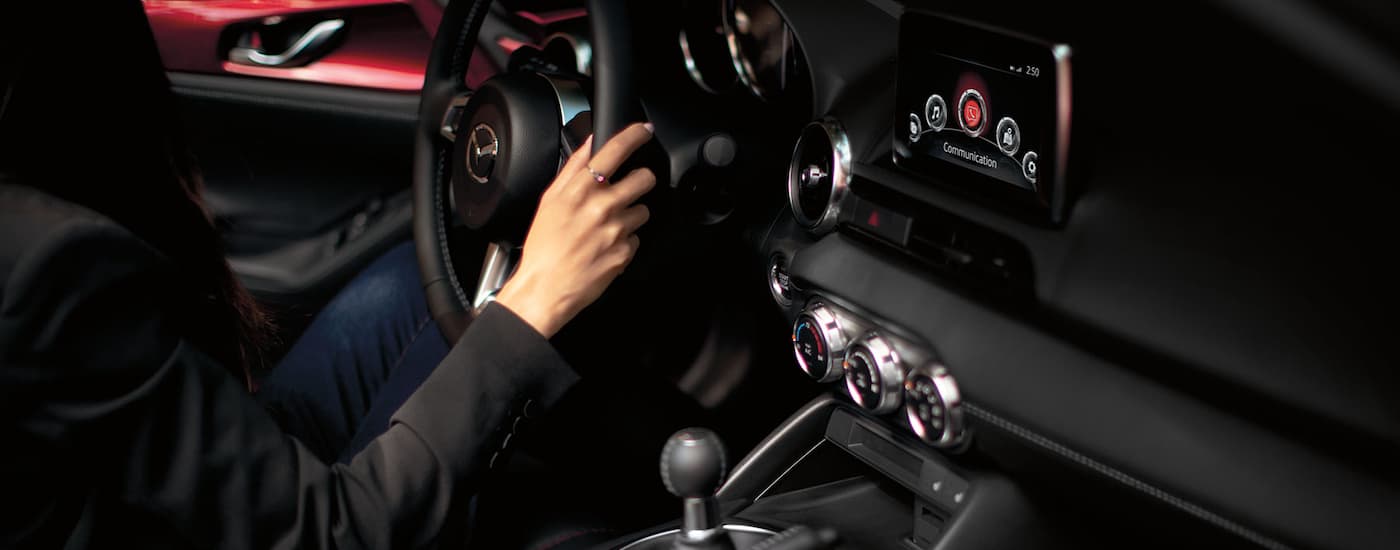 Closeup of a woman's hand on the steering wheel of a Mazda vehicle