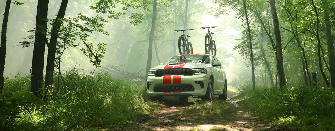 A white 2020 Dodge Durango SRT is shown parked on a trail in the woods.