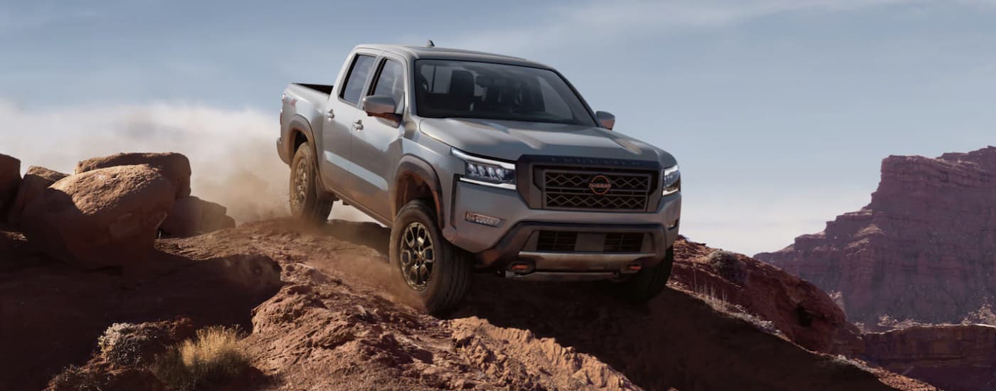 Grey 2022 Nissan Frontier PRO-4X off-roading in the mountains after leaving a Nissan dealer