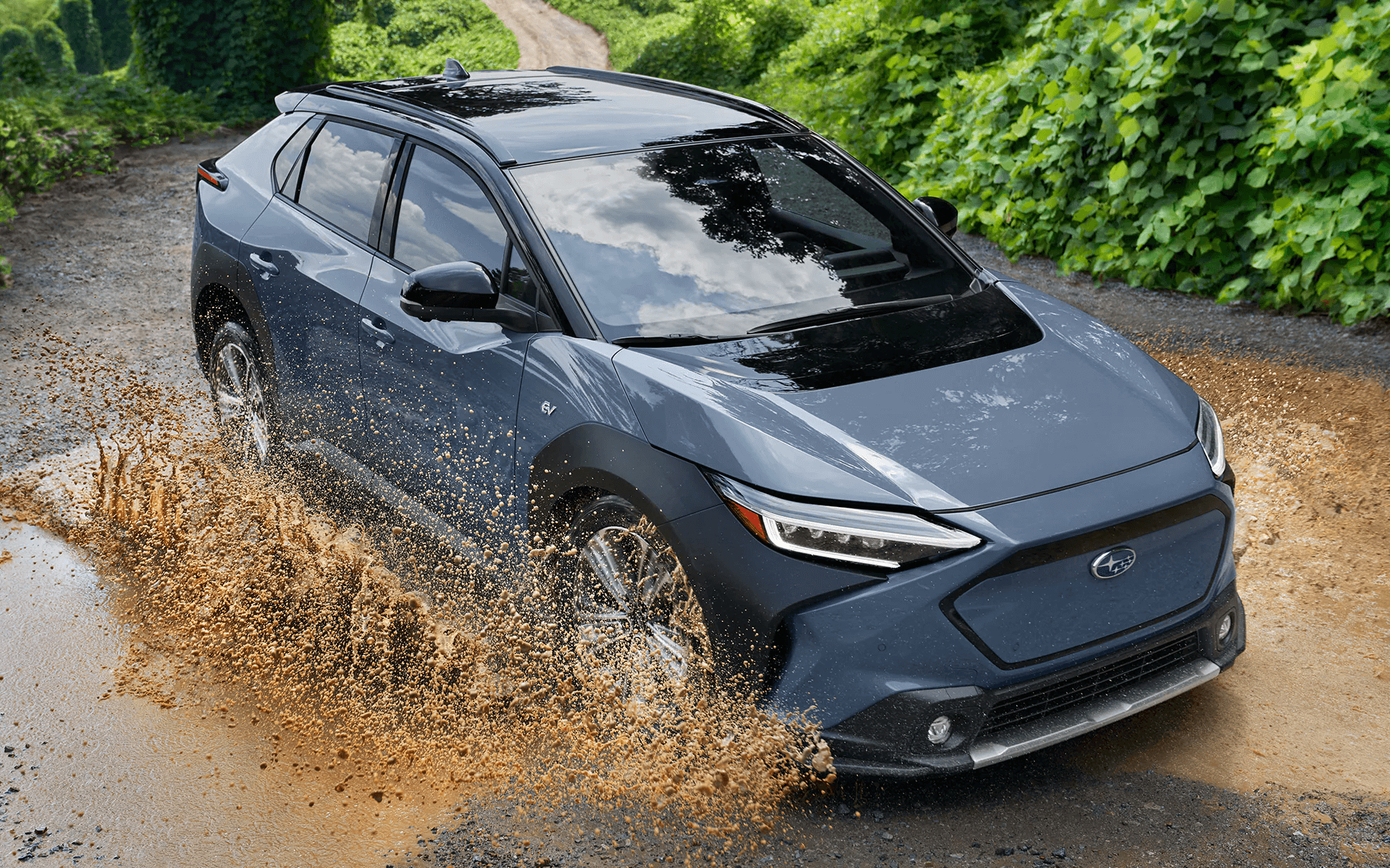 2023 Solterra driving through a puddle of muddy water.