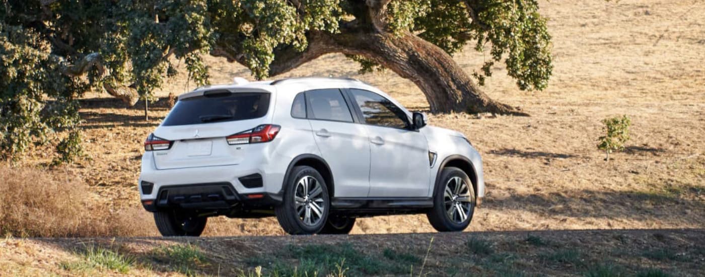 A white 2022 Mitsubishi RVR is shown from the side parked in a field.