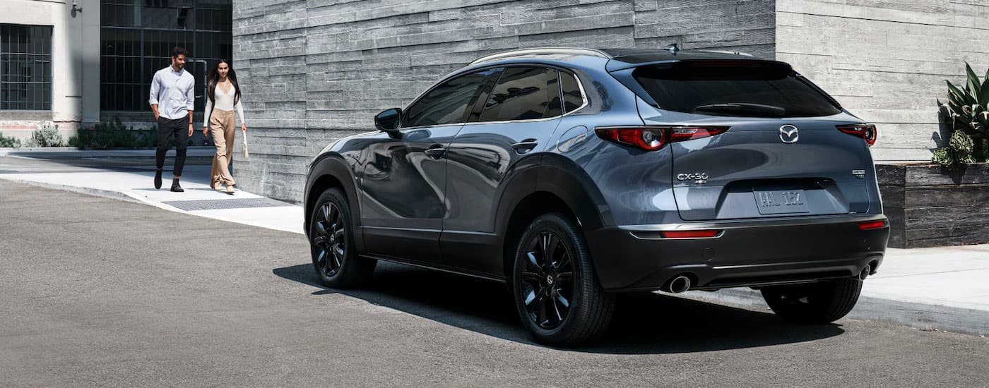 A dark blue 2020 Mazda CX-30 is shown parked on a city street after leaving one of the most popular car dealerships in Edmonton.