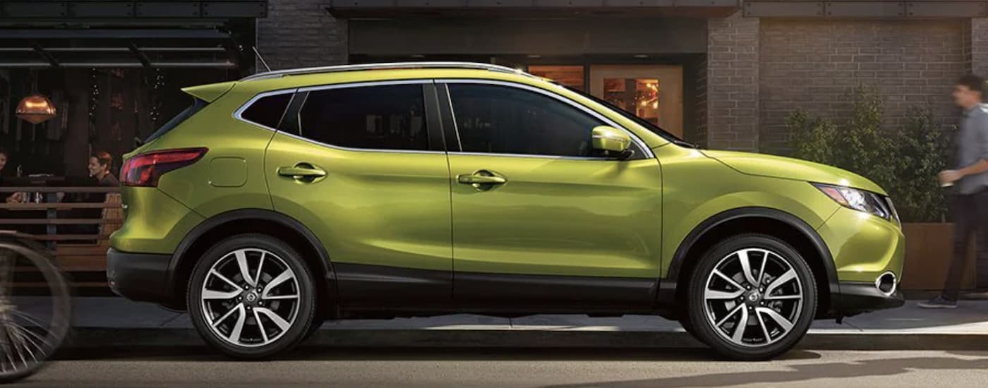 A neon green 2022 Nissan Qashqai is shown from the side parked on a city street after leaving a Nissan dealer in Beaumont.