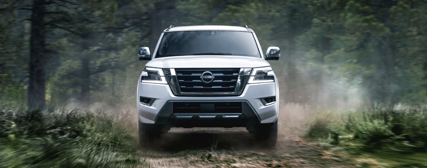 A white 2022 Nissan Armada is shown from the front driving on a dirt path.