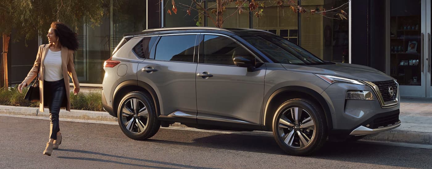 A grey 2022 Nissan Rogue is shown from the side parked on a city street.