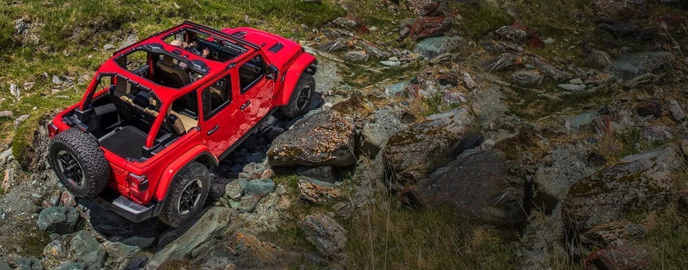 A red 2019 Jeep Wrangler Rubicon is shown from above off-roading.