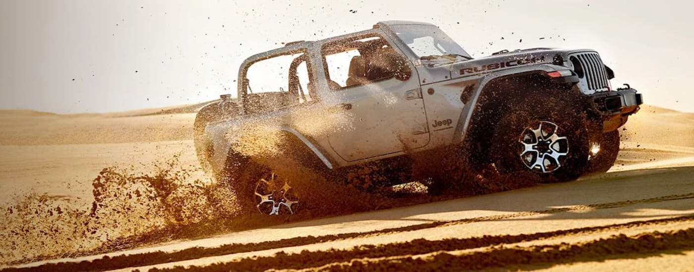 A silver 2020 Jeep Wrangler Unlimited is shown from the side off-roading after leaving a Edmonton used Jeep Wrangler dealer.