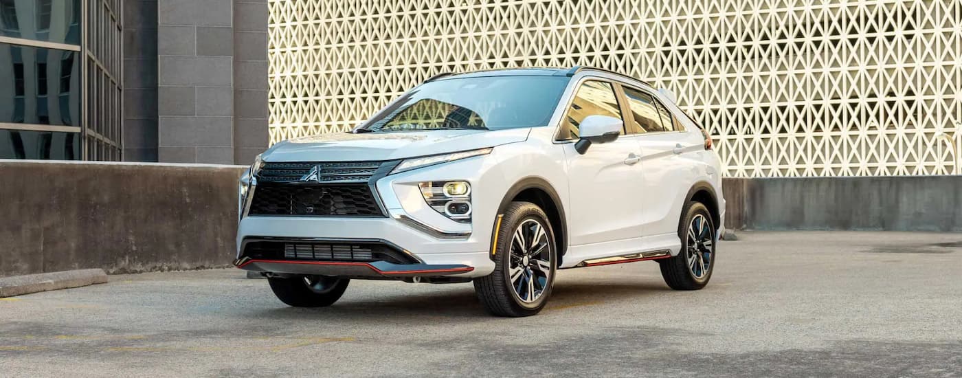 One of the most popular Mitsubishi SUVs, a white 2023 Mitsubishi Eclipse Cross, is shown parked on concrete.