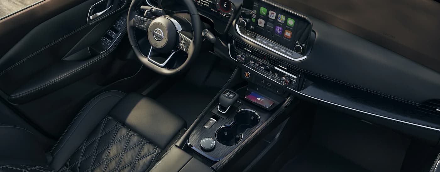 The black interior of a 2022 Nissan Rogue is shown at a Nissan Rogue dealer.