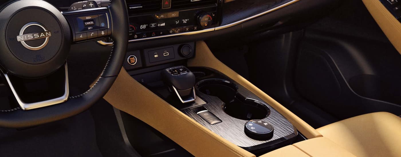 The tan and black interior of a 2022 Nissan Rogue is shown at a Nissan Rogue dealer.