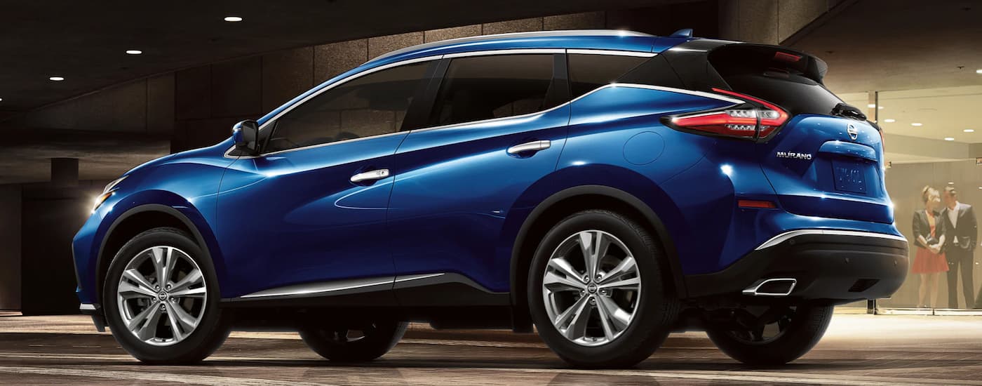 A blue 2022 Nissan Murano is shown from the side parked outside of a hotel.