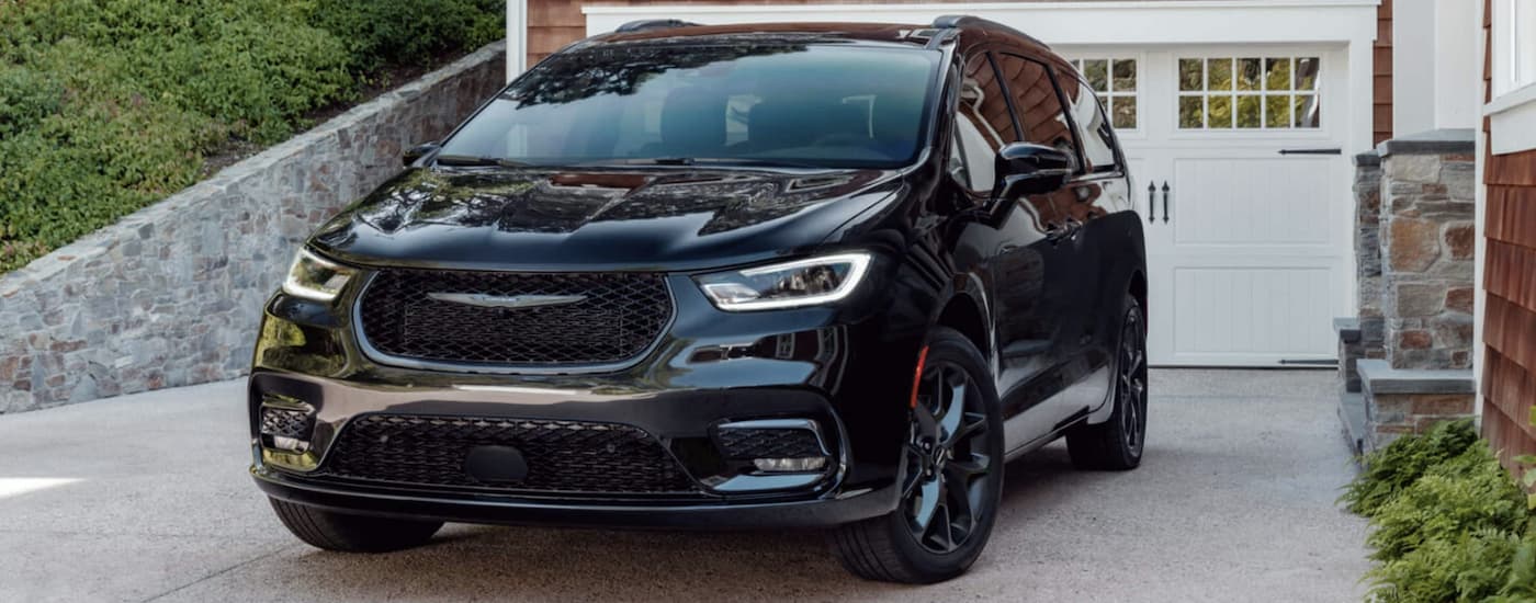 A black 2022 Chrysler Pacifica is shown in a driveway after leaving a Pacifica dealer.