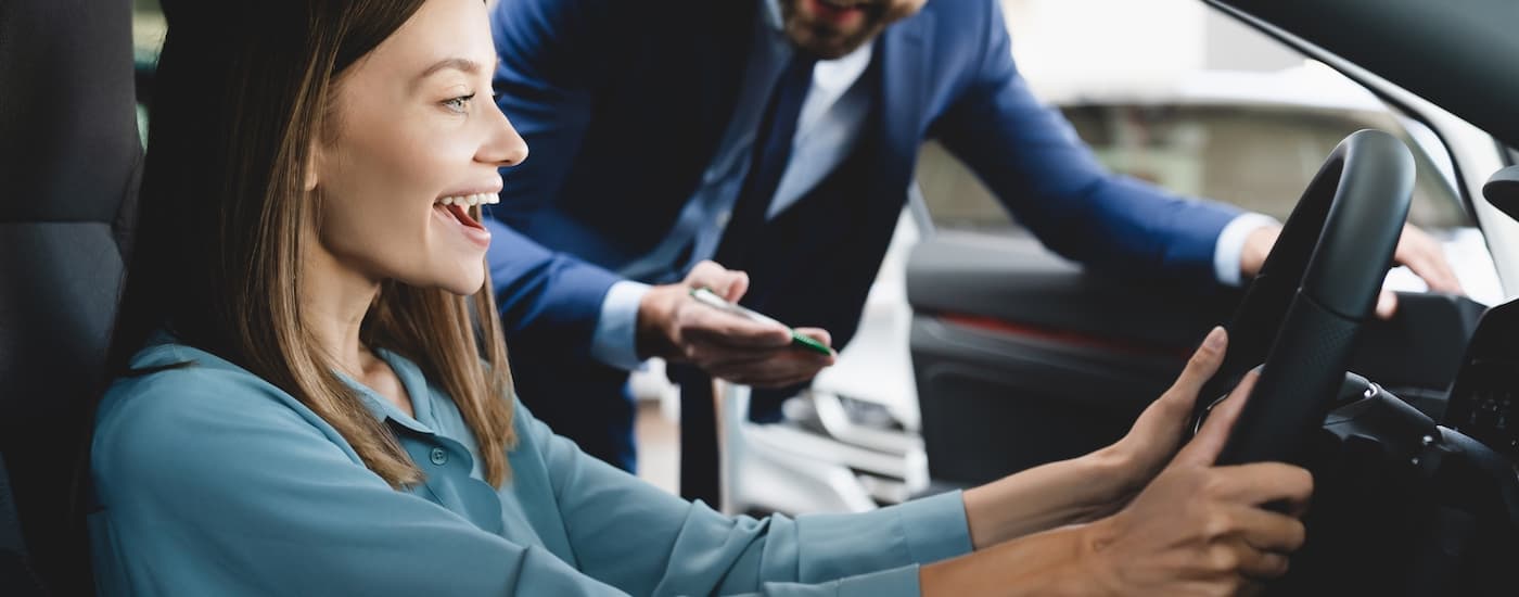 A person is shown sitting in the front seat of a vehicle after learning about bankruptcy auto loans.
