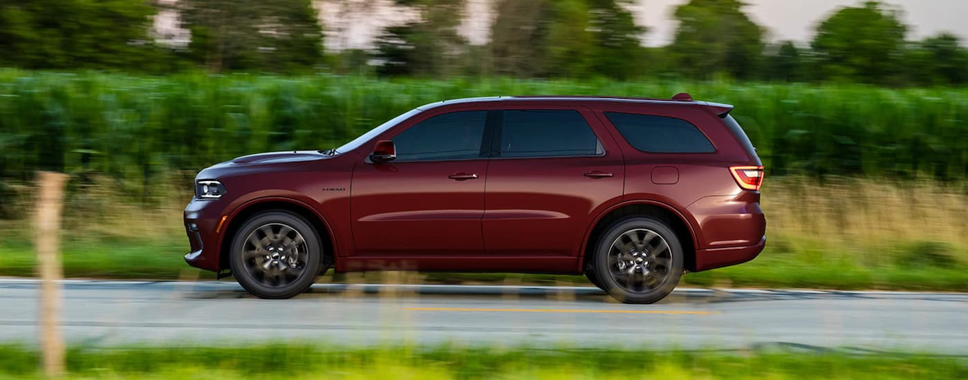 A red 2022 Dodge Durango SRT is shown from the side driving next to tall grass.