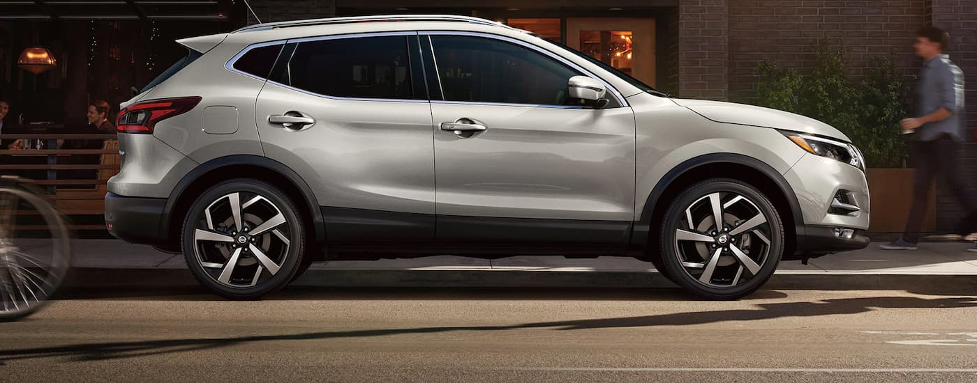 A silver 2022 Nissan Qashqai is shown from the side on a city street.