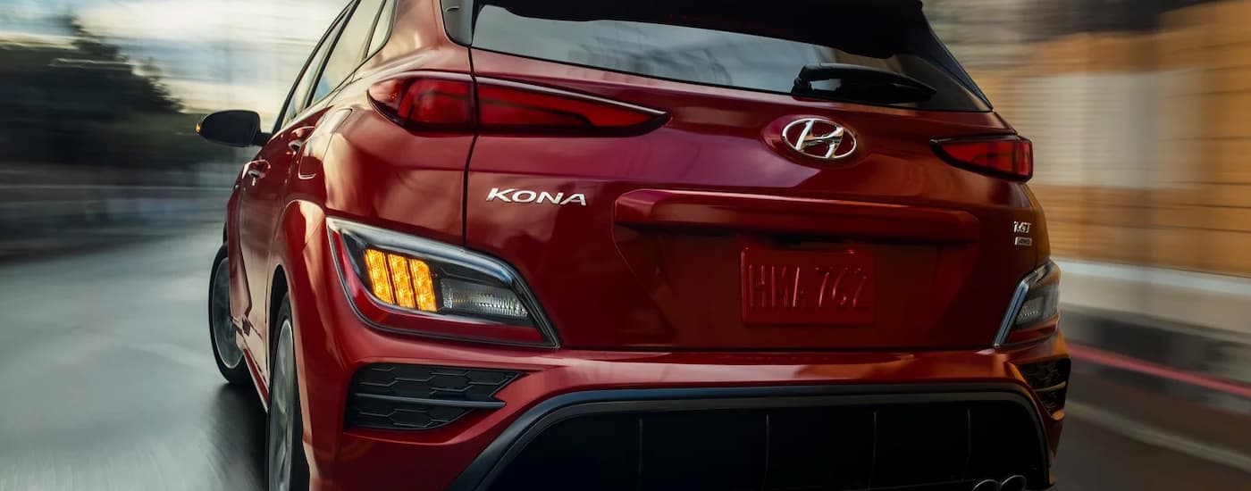 A close up of the rear of a red 2022 Hyundai Kona N-Line is shown while turning a corner.