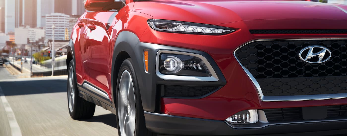 A close up of the grille on a 2019 Hyundai Kona is shown while driving on a city street.