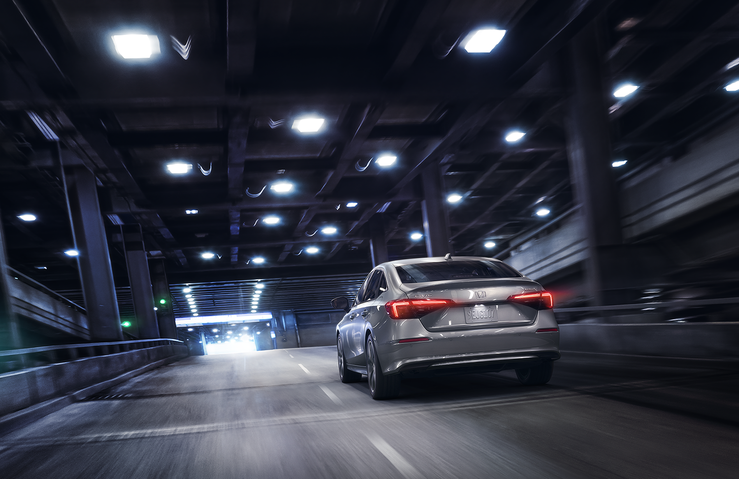 2023 Honda Civic sedan silver driving in tunnel, rear view of vehicle 