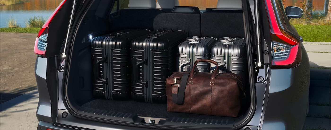 A 2023 Honda CR-V Hybrid Sport Touring with a trunk full of luggage.