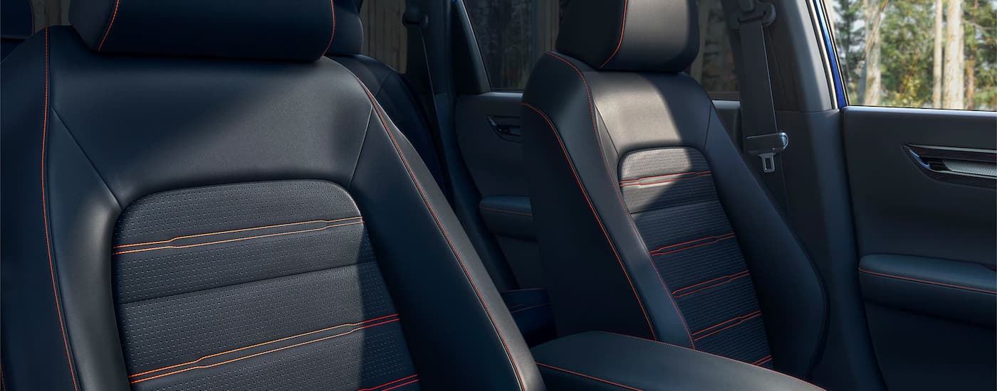 A close up of black leather seats with orange stitching in a 2023 Honda CR-V Hybrid Sport Touring.