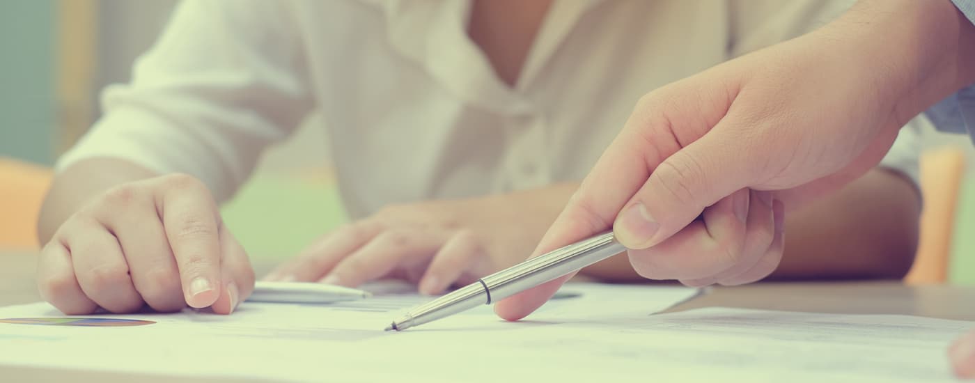 Two people are shown talking about finance paperwork.