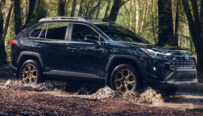 El vehículo que se muestra es el Toyota RAV4 2023 Hybrid Woodland Edition en Midnight Black Metallic.